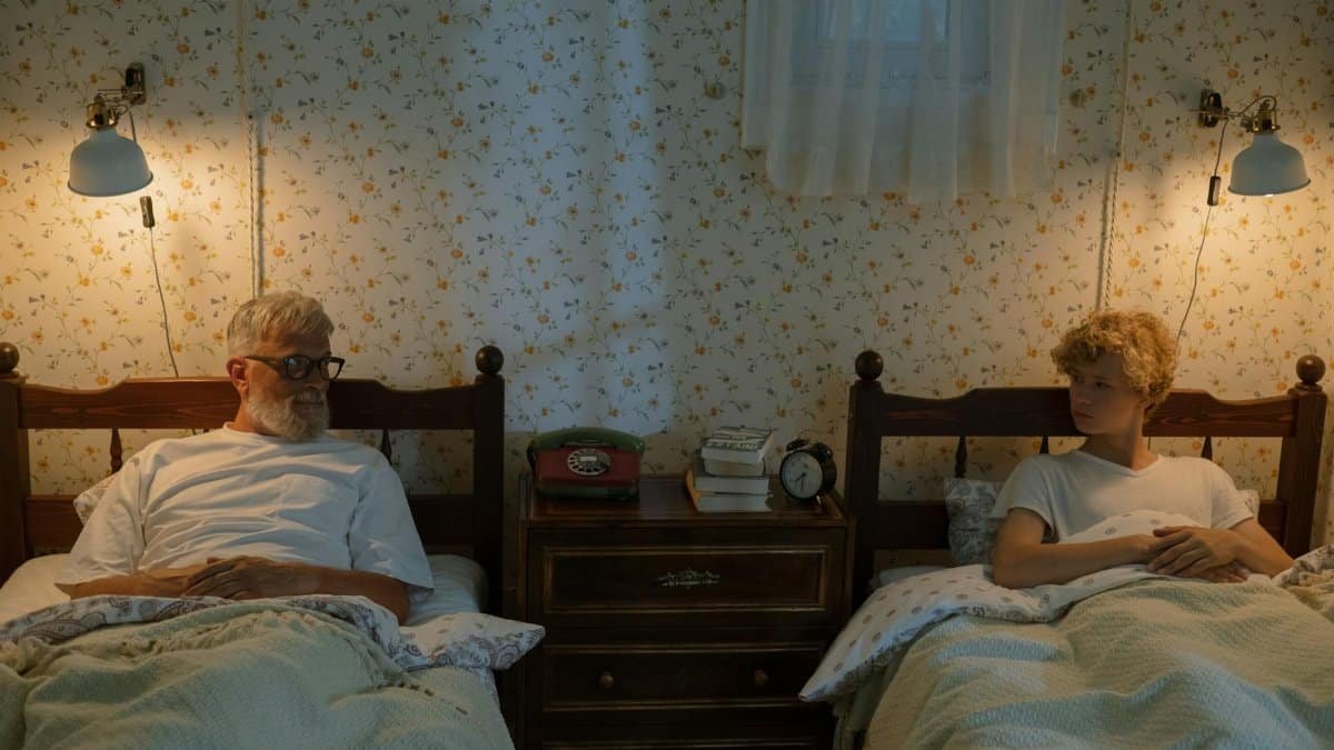 A grandfather and grandson sharing stories in their cozy bedroom at night.