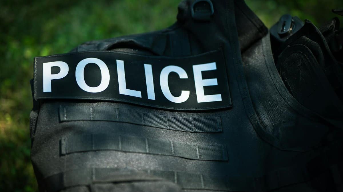 Detailed shot of a police vest lying outdoors, highlighting law enforcement gear.