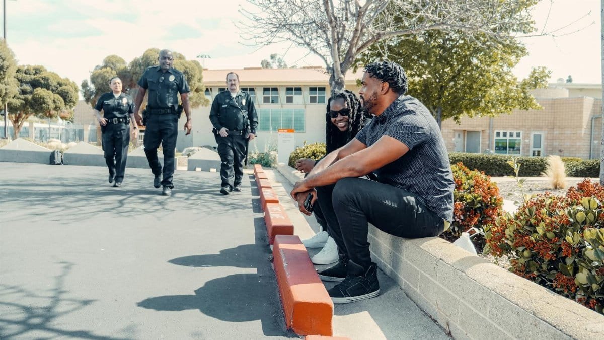 Police officers engaging with civilians outdoors in a friendly urban environment.