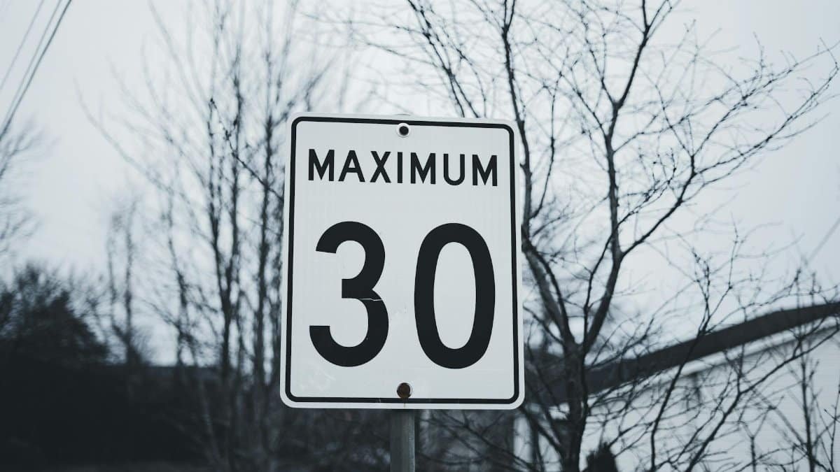 Photograph of a road sign indicating a maximum speed limit of 30 in a winter setting.