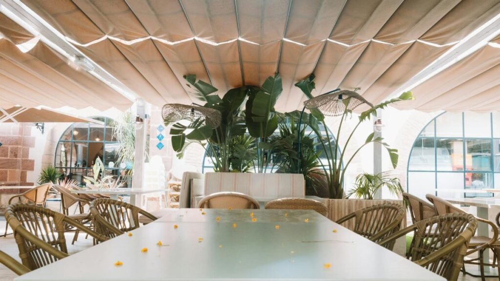 Charming outdoor restaurant with wicker chairs in Benidorm, Spain under a canopy.