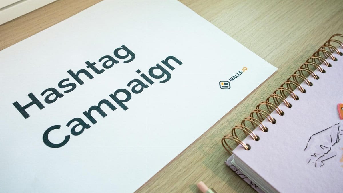 A clean office desk setup featuring hashtag campaign marketing materials and a planner.