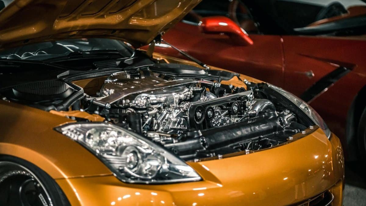 From above of modern shiny polished engine with details under hood of expensive car parked at parking lot