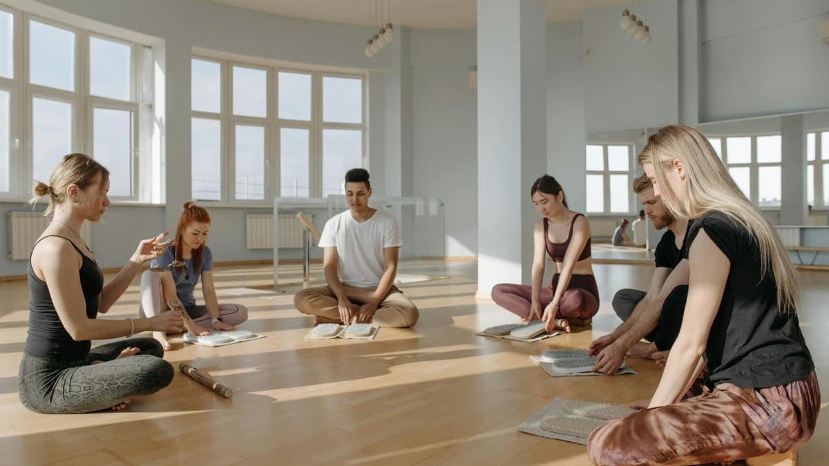 A diverse group of people meditating together indoors, creating a serene and peaceful environment.