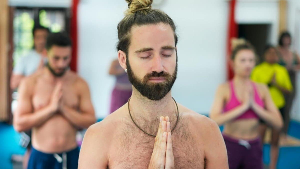 A diverse group of individuals meditating during a yoga class, focusing on mindfulness.
