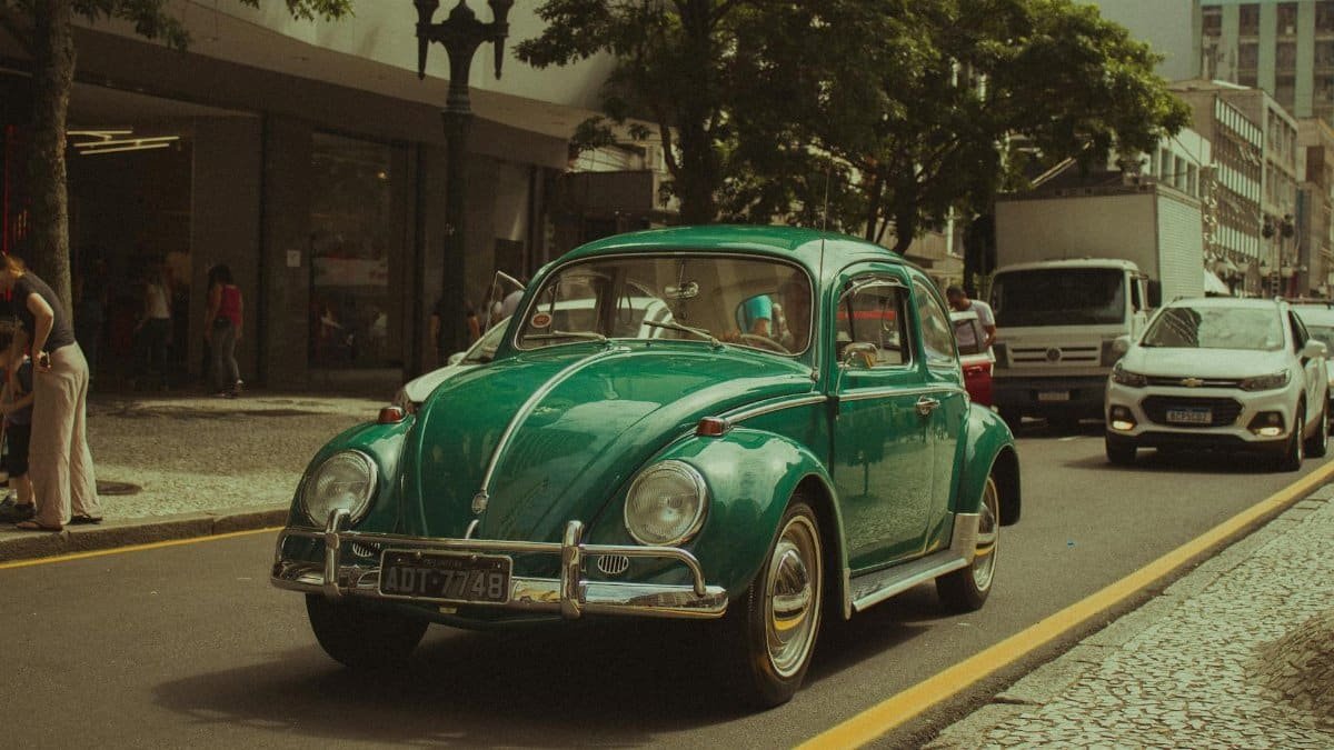 Classic green vintage car on an urban city street with old charm.