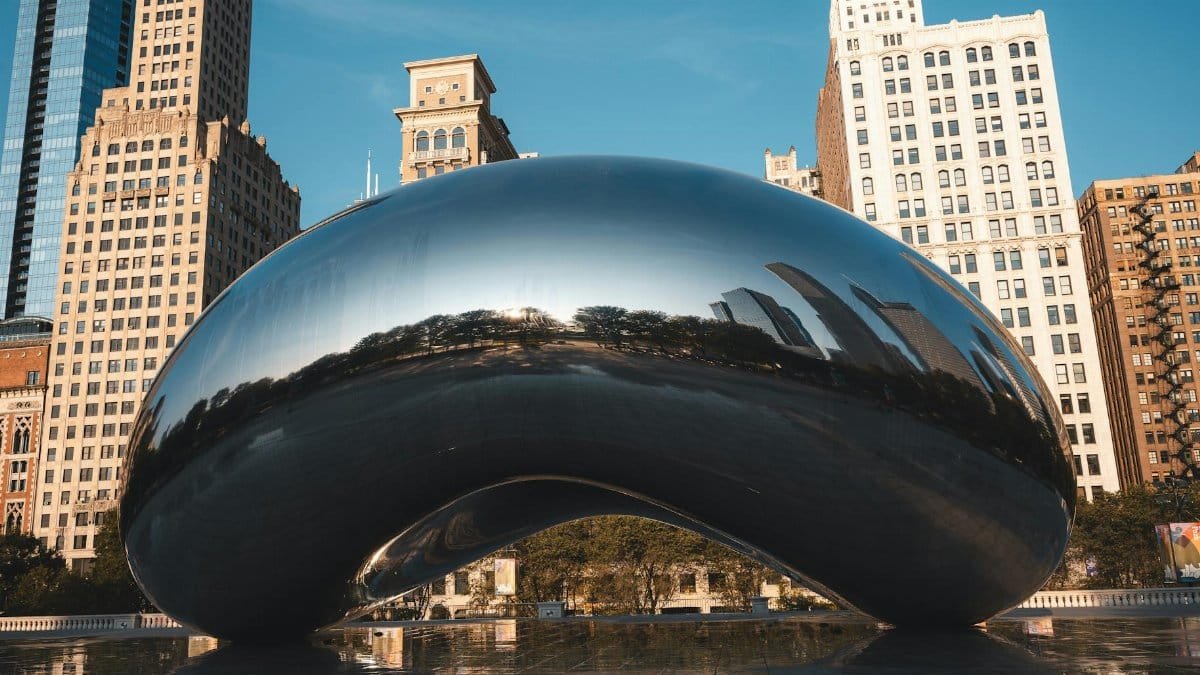 Daytime view of Cloud Gate sculpture surrounded by Chicago's skyline.