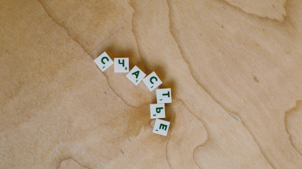 Wooden scrabble tiles spelling a Russian word on a wooden surface, creating a minimalist and conceptual image.