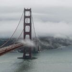 Aerial view of the Golden Gate Bridge enveloped in fog over San Francisco Bay.