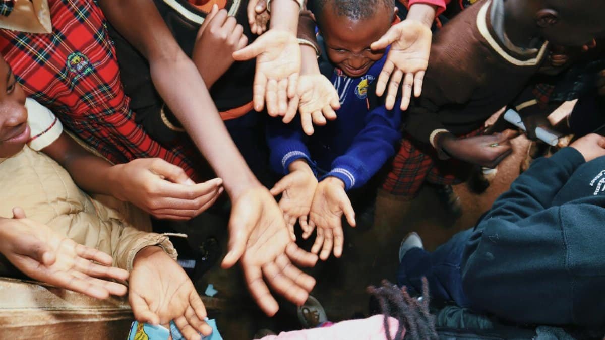 A diverse group of children reaching out their hands, symbolizing unity and hope.