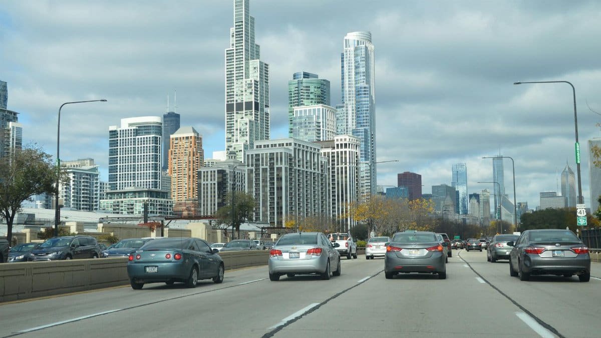 View of Chicago's skyline with dense traffic on a busy highway, showcasing iconic skyscrapers.