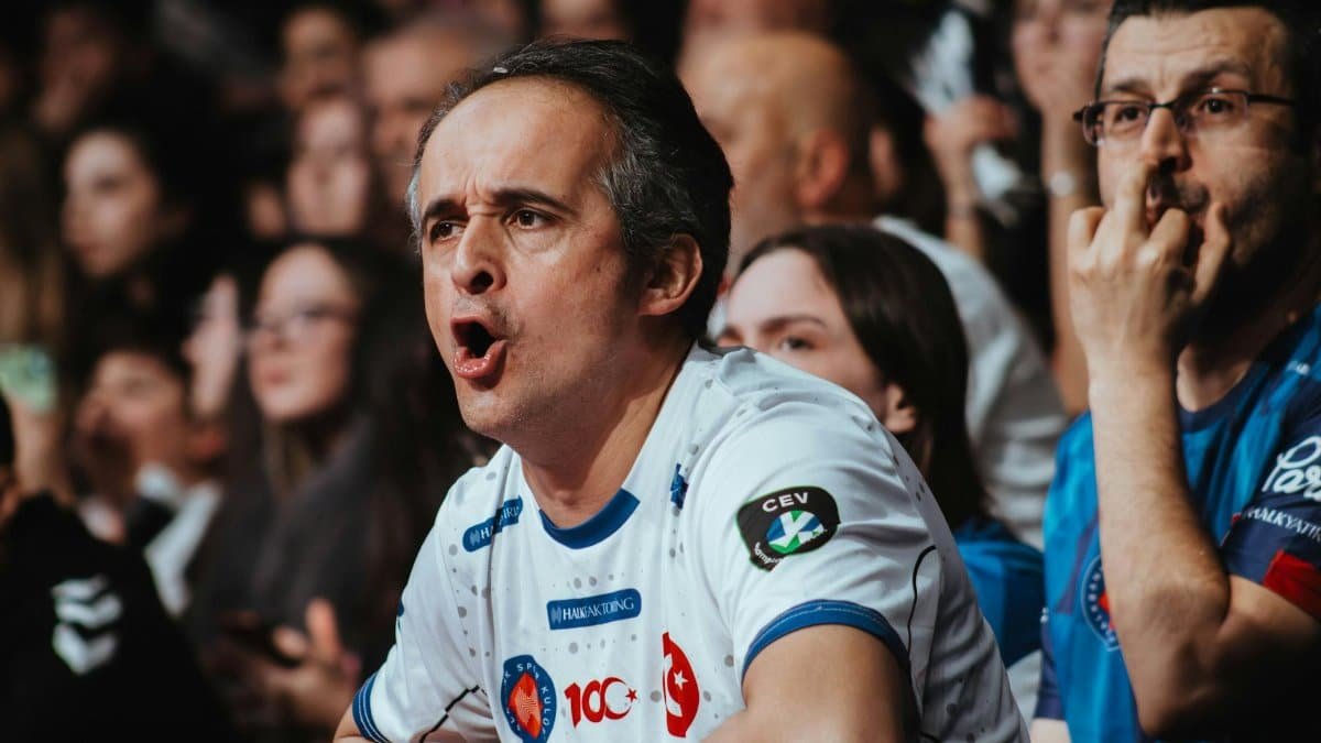 Passionate fans in a crowd showing excitement at a sports event. Engaging atmosphere and team spirit.