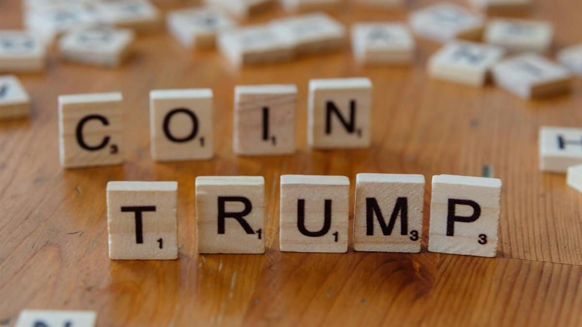 Scrabble tiles spelling 'TRUMP' on a wooden table, creating a political theme.