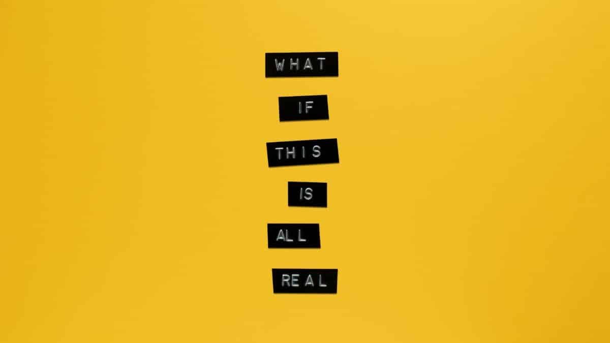 Inspirational text 'What if this is all real' on yellow surface.