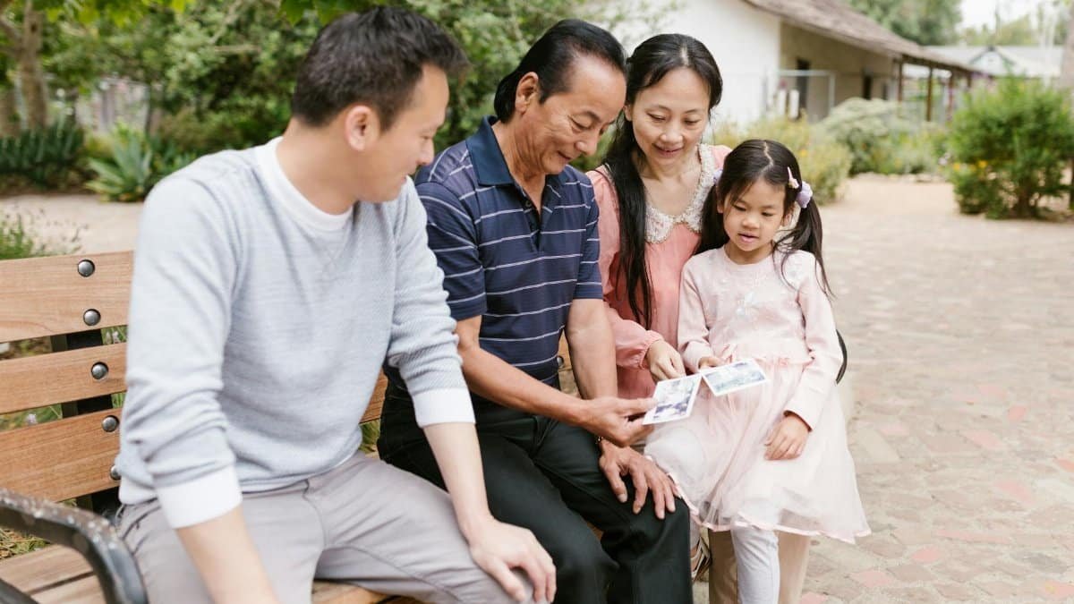 Family enjoying a sunny day in the park, sharing photos and creating memories.