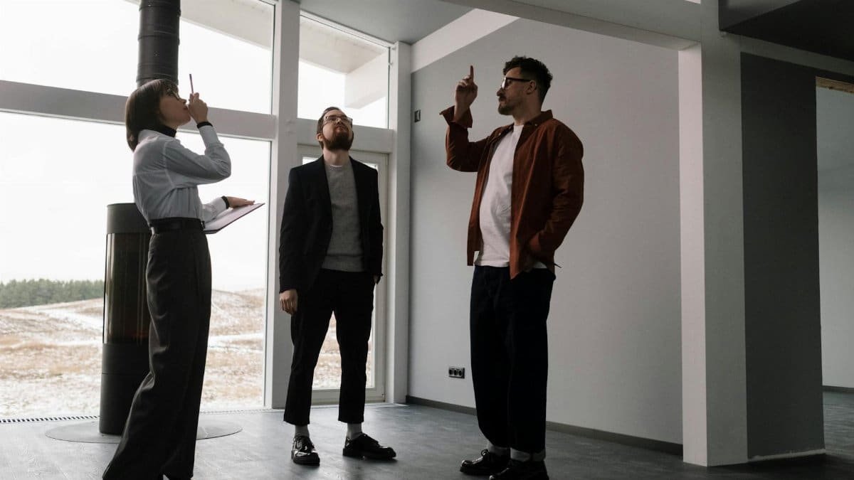 Three real estate agents discussing design in a modern apartment space.