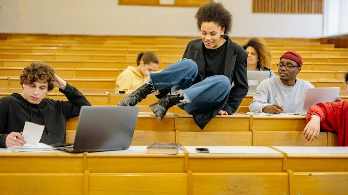 Diverse students interact and study in a university lecture hall.