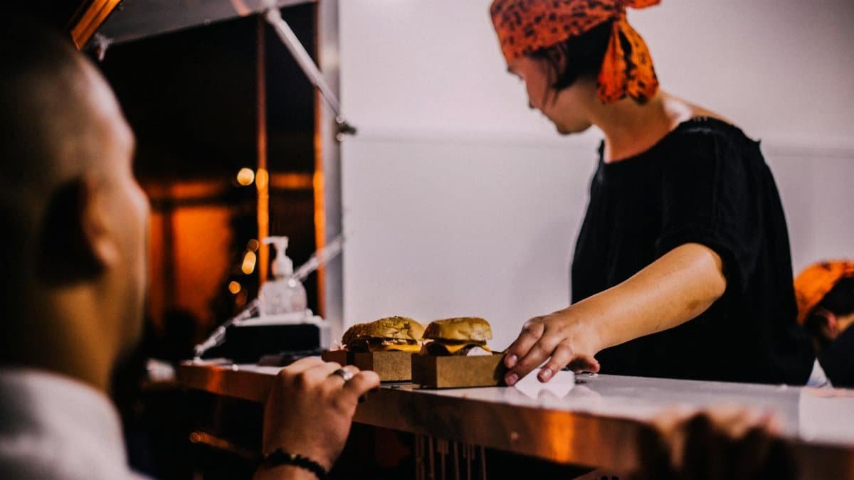 A street vendor in Maceio, Brazil serves burgers at a night market food stall.
