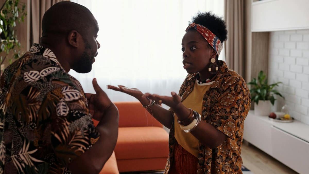 A couple arguing passionately in their living room, expressing emotions and gestures.