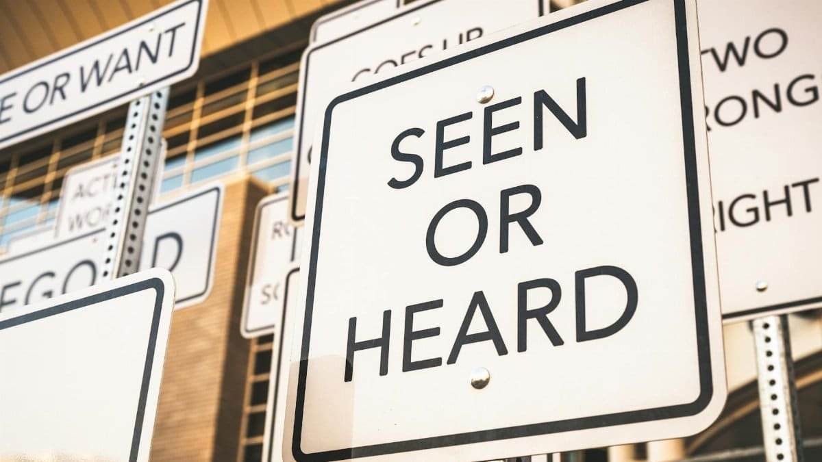 Creative street signs with thought-provoking messages and wordplay in an urban setting.