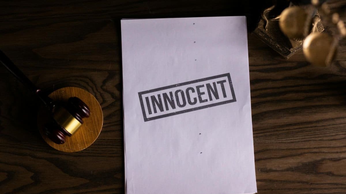 Close-up of legal document stamped 'Innocent' beside a gavel on a wooden desk.