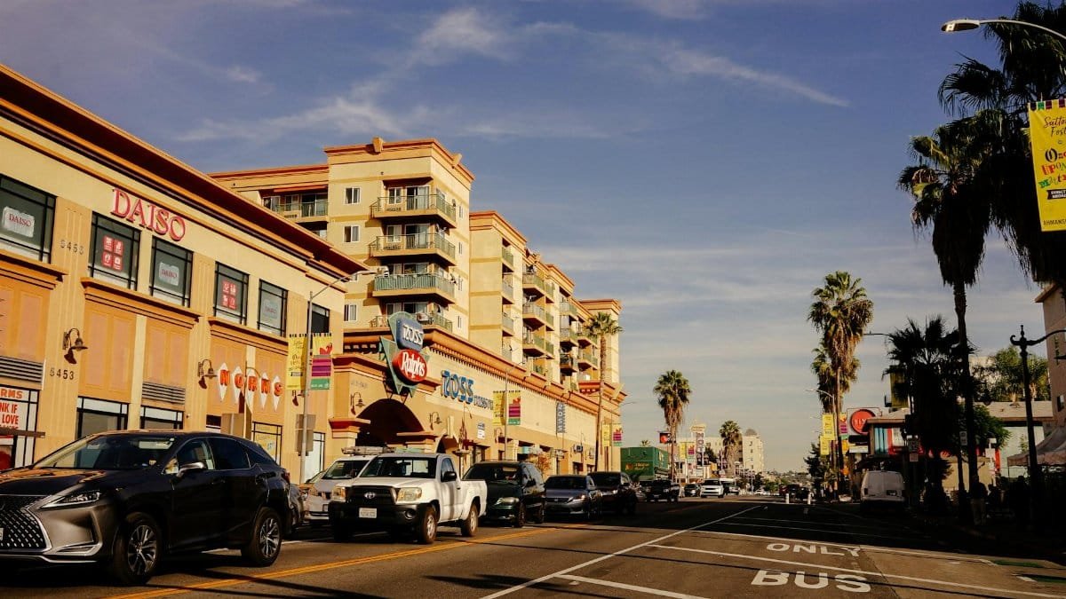 Vibrant city street scene showcasing traffic and popular stores on a sunny day.