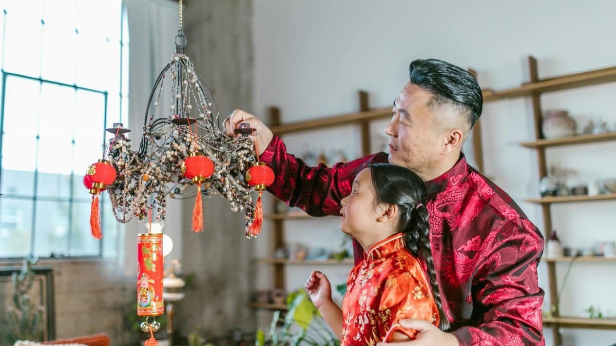 Father and daughter enjoying bonding time decorating with lanterns indoors.