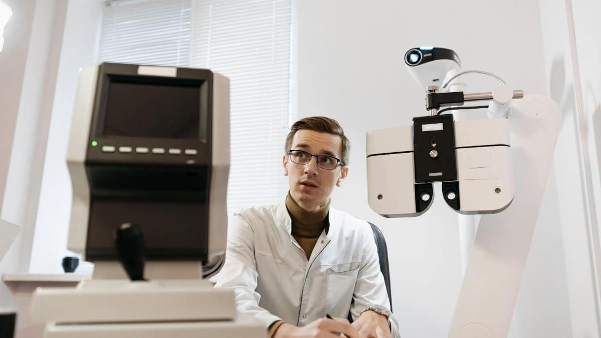 Optician in a clinic performing an eye examination with advanced vision testing equipment. Professional setting.