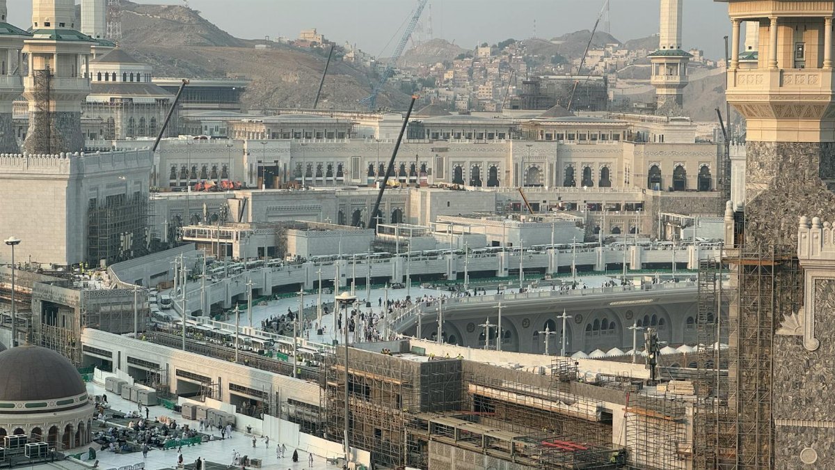 Aerial view of the Grand Mosque in Mecca, Saudi Arabia, showing ongoing construction and surrounding architecture.