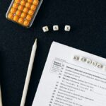 Flat lay of tax form, pencils, and calculator on black background, emphasizing tax deductions.