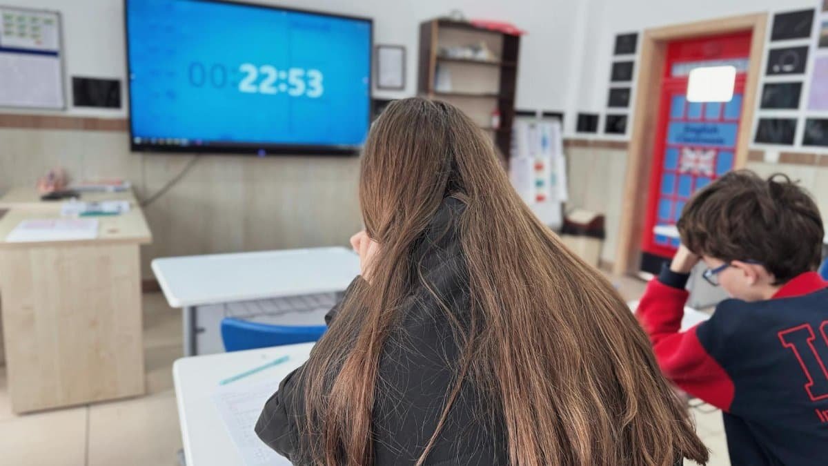 Students concentrating in a modern classroom with a digital timer on screen.