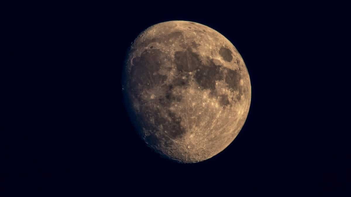 A detailed view of the waxing gibbous moon against a dark night sky, showcasing lunar craters and textures.
