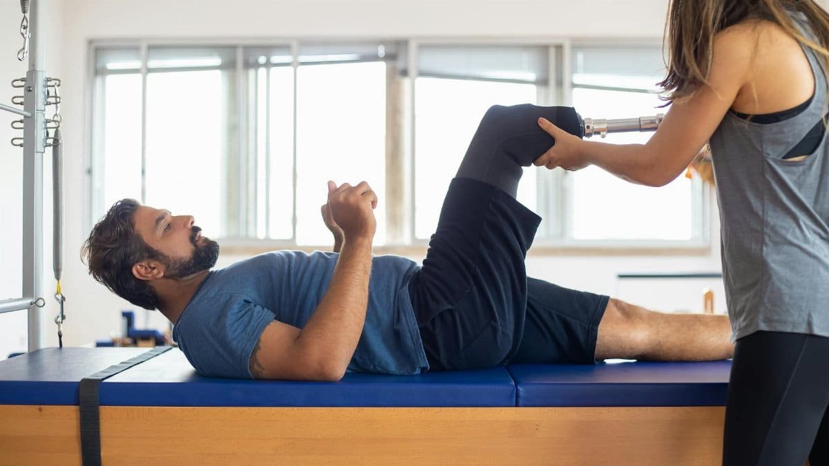 Man and woman engaging in a physical therapy session, focusing on prosthetic leg recovery and rehabilitation.