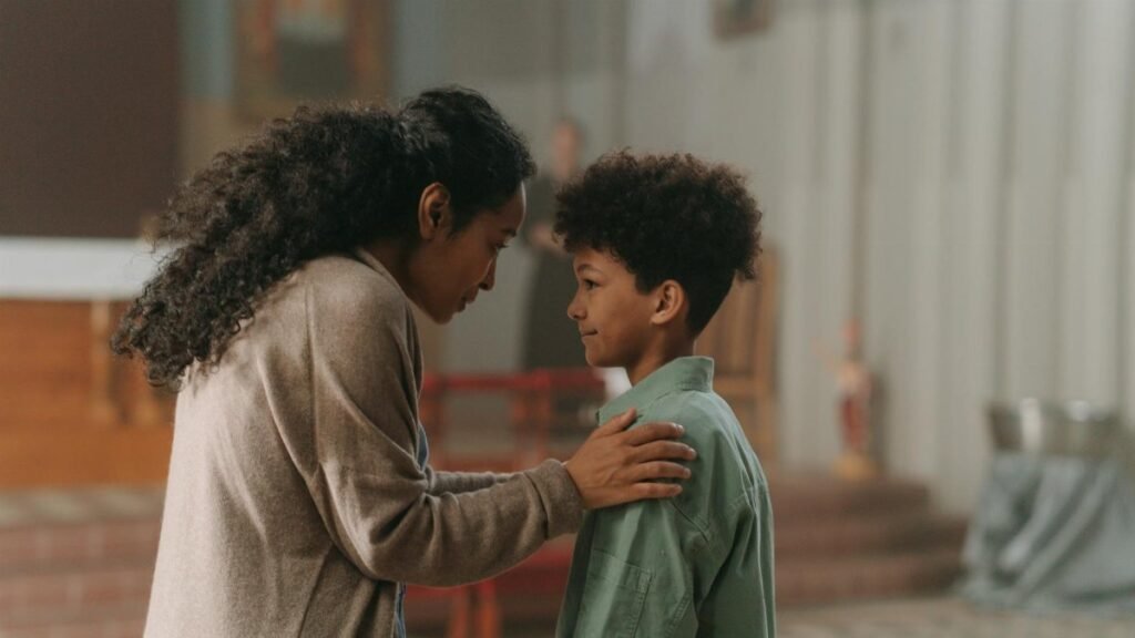 A mother and son share a tender moment inside a church, emphasizing family bond.