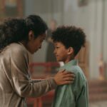 A mother and son share a tender moment inside a church, emphasizing family bond.