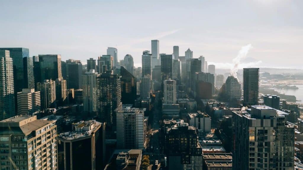 Explore a stunning aerial view of Seattle, highlighting its iconic skyline on a bright, sunny day.