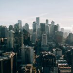 Explore a stunning aerial view of Seattle, highlighting its iconic skyline on a bright, sunny day.