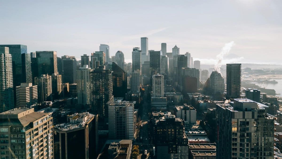 Explore a stunning aerial view of Seattle, highlighting its iconic skyline on a bright, sunny day.