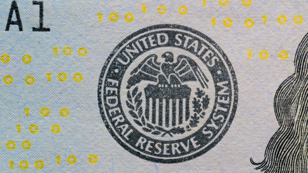 Detailed view of the US Federal Reserve System seal on currency with yellow digital numbers.