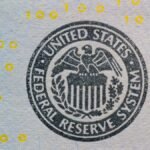 Detailed view of the US Federal Reserve System seal on currency with yellow digital numbers.