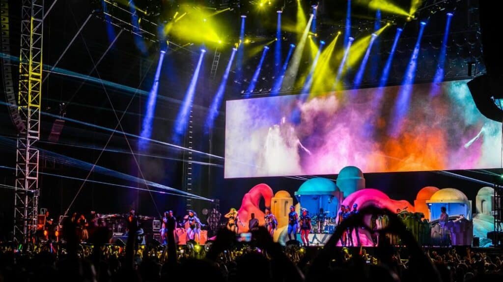 Energetic concert scene with colorful lights and performers on stage