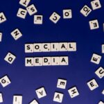 Scrabble tiles spelling 'Social Media' on a blue background, ideal for digital marketing themes.