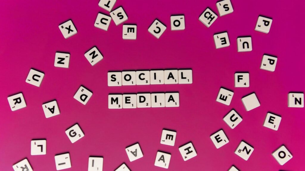 Alphabet tiles forming 'Social Media' on a vibrant pink background, perfect for digital marketing themes.