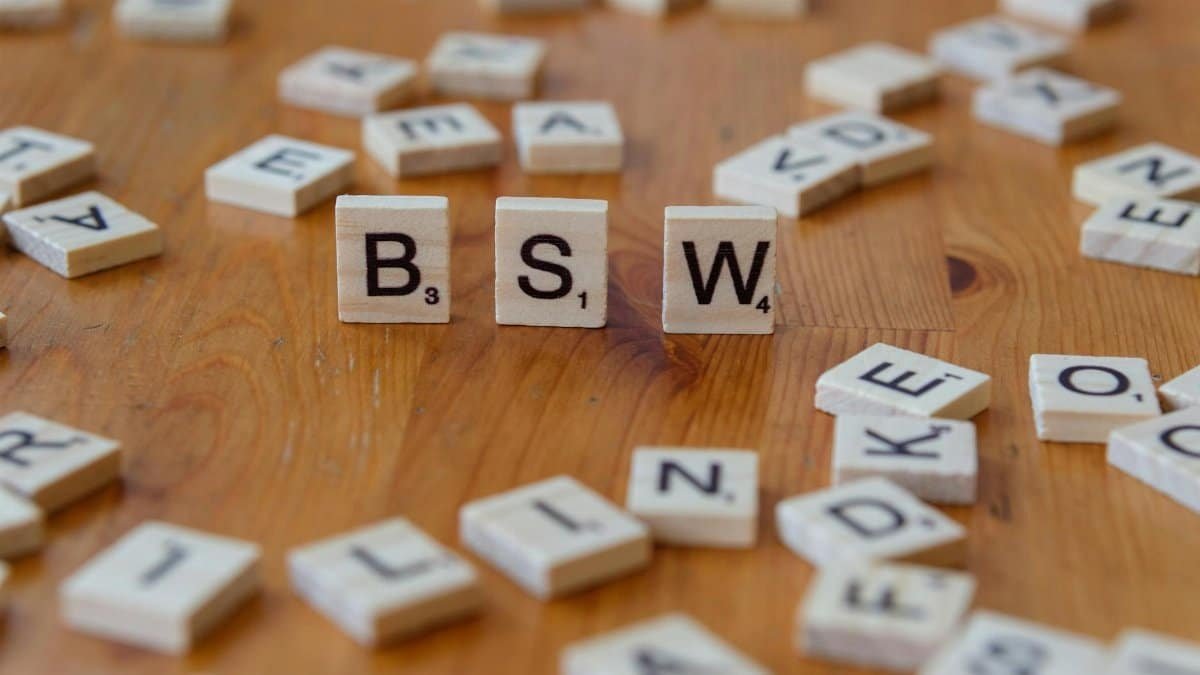 Scrabble tiles spelling 'BSW' on a wooden table, representing Bachelor of Social Work.