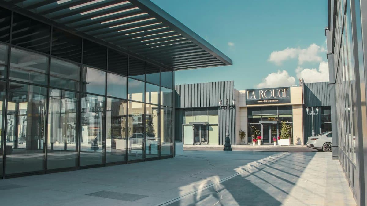 Elegant shopping arcade featuring modern architecture and glass facades under a clear sky.