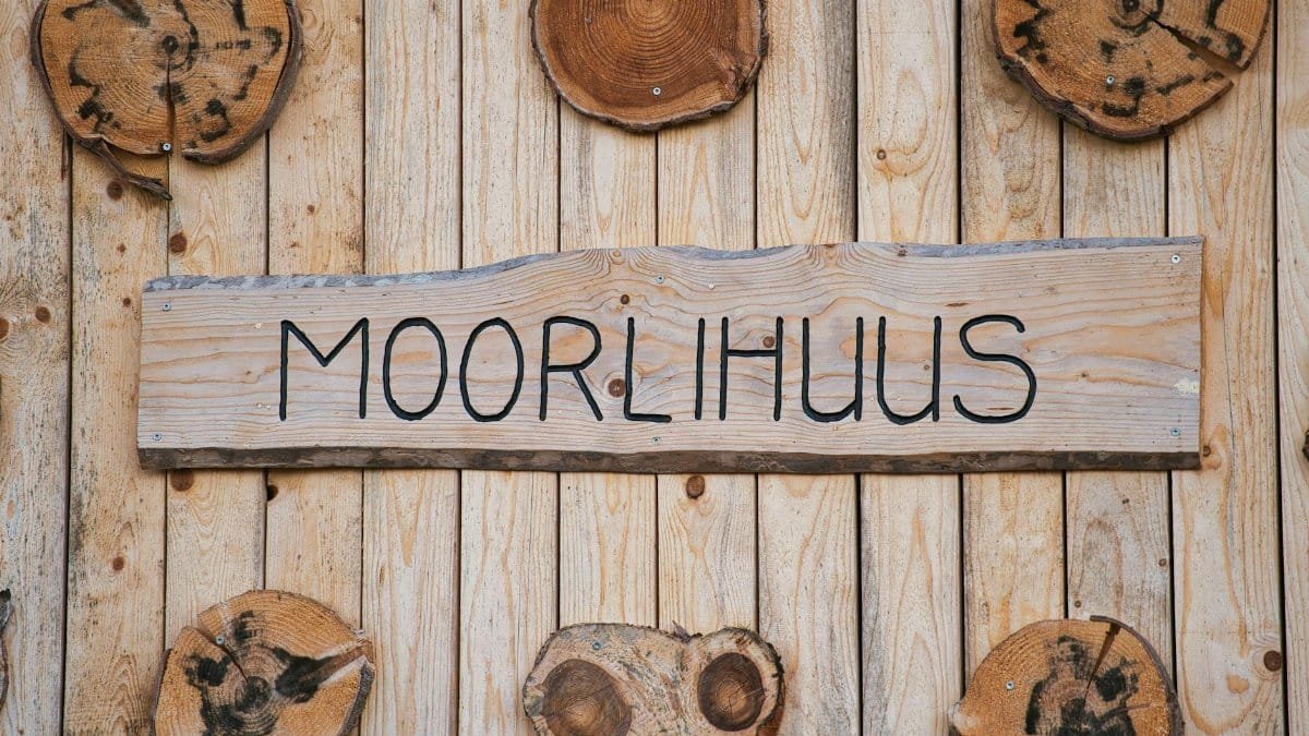 Detailed view of a wooden wall with a prominent Moorlihuus sign and tree cross-sections.