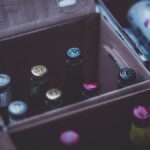 Close-up of various alcohol bottles and cans in cardboard boxes indoors.