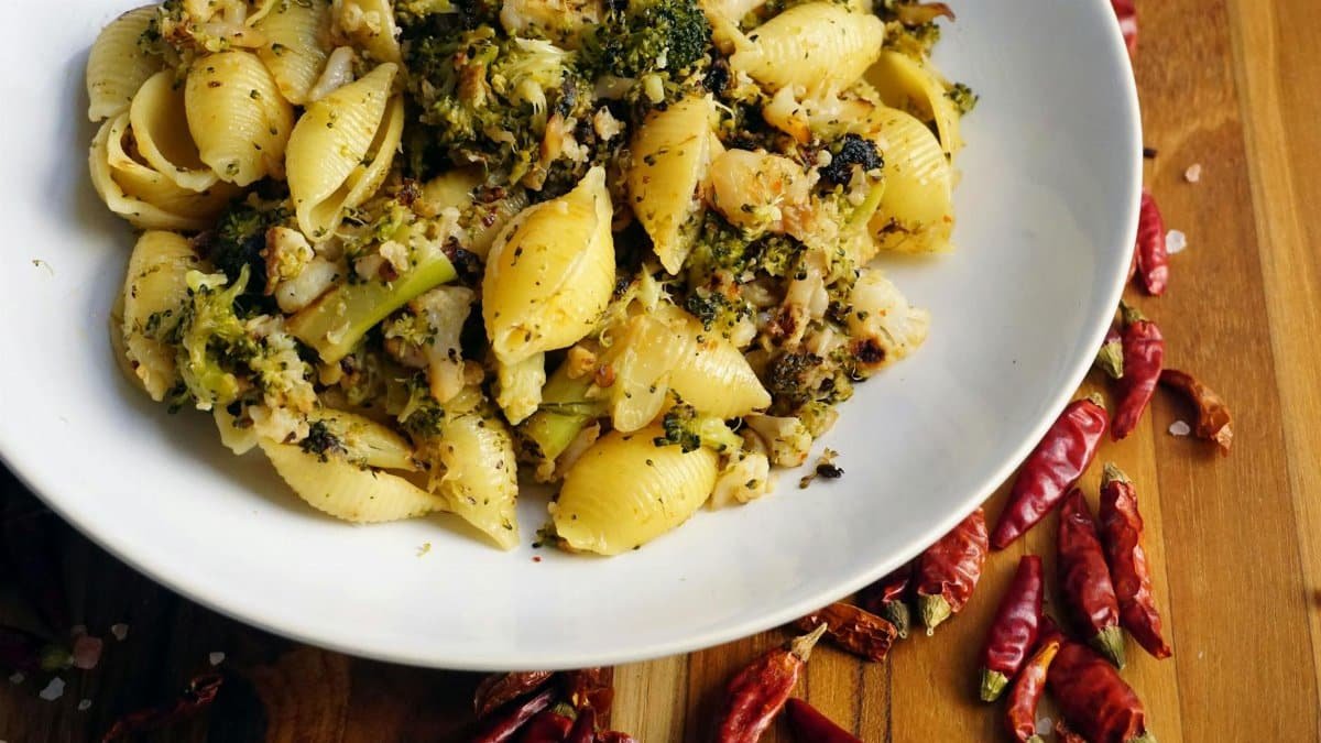 A plate of flavorful broccoli pasta with fresh herbs and red chili for a spicy kick.