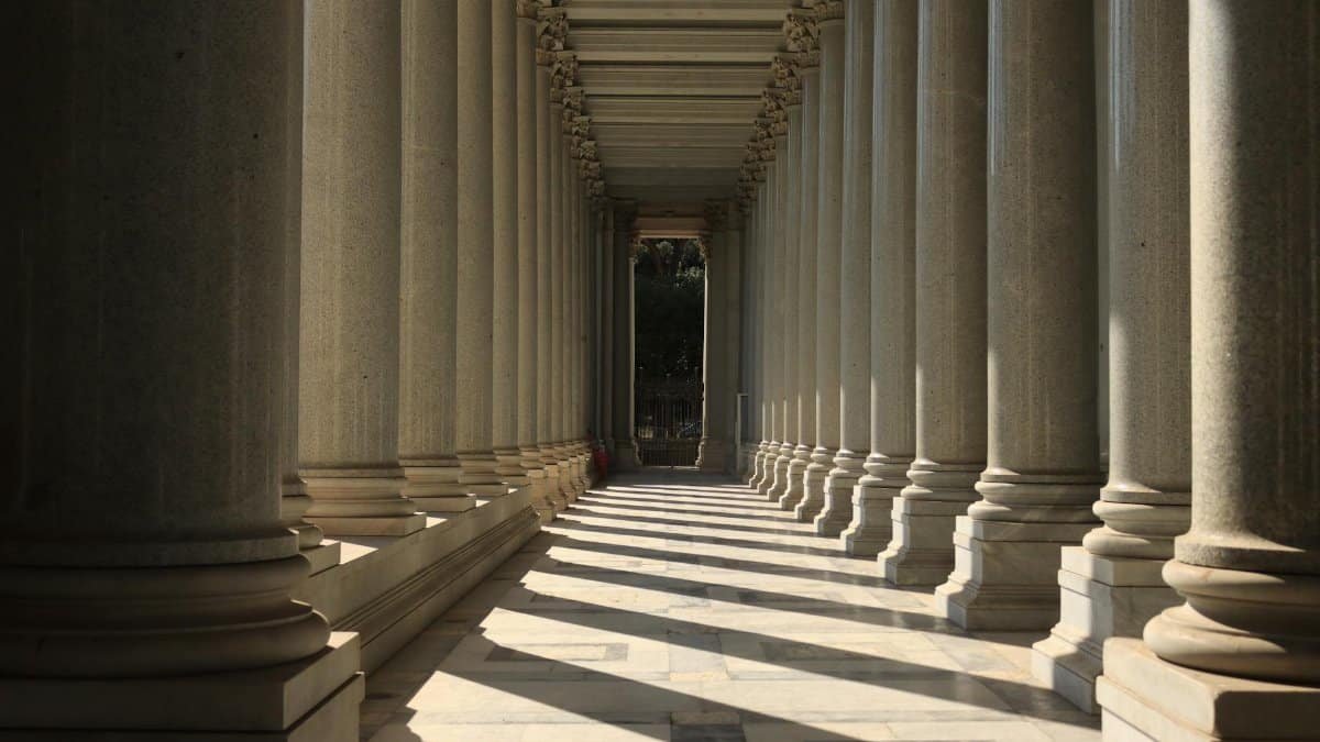 Elegant colonnade with light and shadows in Rome, Italy, highlighting ancient architectural beauty.
