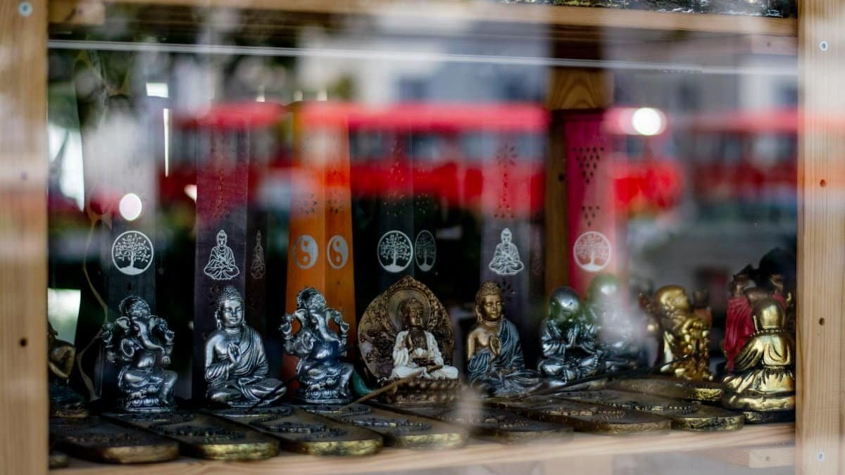 Close-up of spiritual figurines displayed in a Bratislava shop window with colorful decorations.